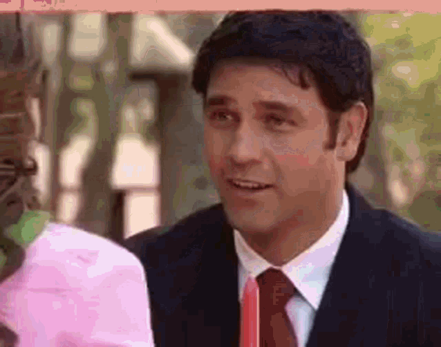 a man in a suit and tie is smiling at a woman