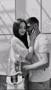 a black and white photo of a man and woman hugging with the man wearing a white shirt that says peace on it