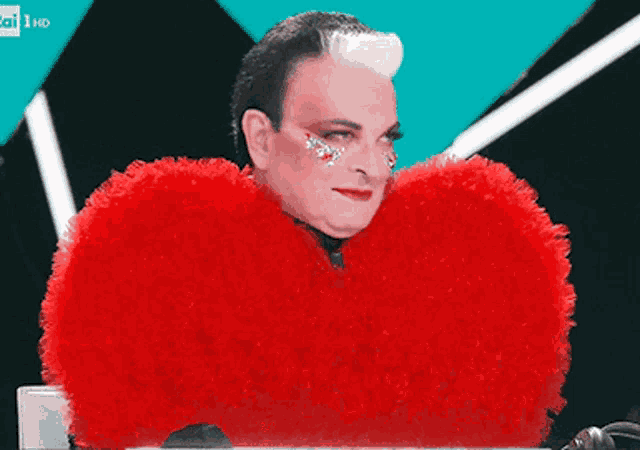 a man is wearing a red heart shaped feathered costume