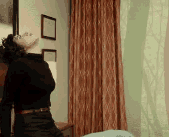 a woman in a black turtleneck is standing in a room