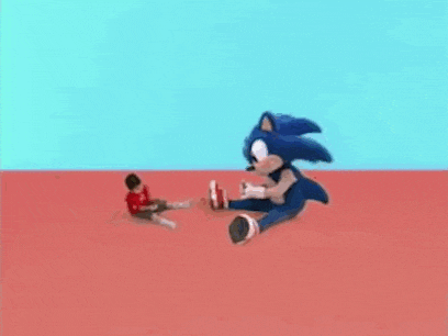 a boy is sitting next to a stuffed sonic the hedgehog on a red floor .