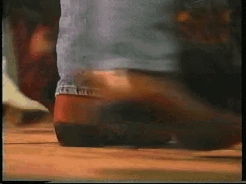 a blurry picture of a person 's feet wearing cowboy boots