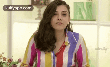 a woman in a colorful striped shirt is making a face .