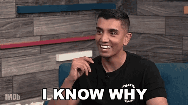 a man sitting on a couch with the words " i know why " on his shirt
