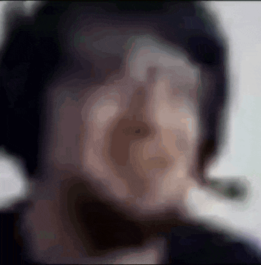 a blurry picture of a person 's face with a cigarette in his mouth