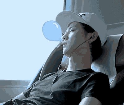 a man wearing a hat with the letter t on it is sleeping in a chair