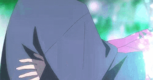 a close up of a person wearing a hooded jacket with a pink scarf around their neck .