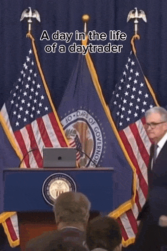 a man stands at a podium in front of an american flag with the words a day in the life of a daytrader above him