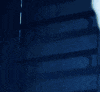 a close up of a robot 's face with glowing eyes in a dark room .