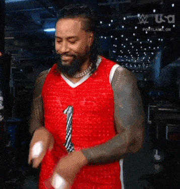 a man with a beard is wearing a red basketball jersey with the number 1 on it .