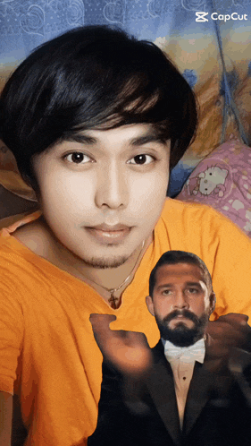 a man in an orange shirt has a picture of a man in a tuxedo in front of his face