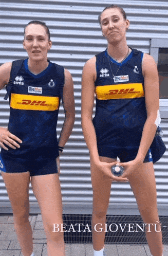 two female volleyball players wearing dhl shirts pose for a picture
