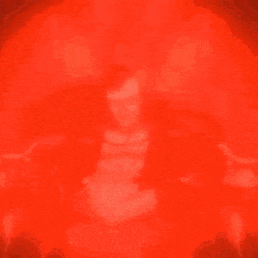 a man without a shirt is sitting in a chair in a dark room