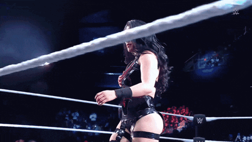 a woman is standing in a wrestling ring with a w logo in the background