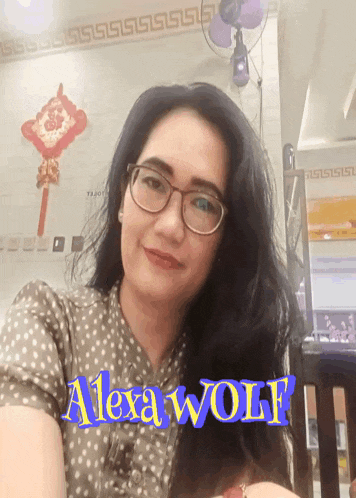 a woman wearing glasses and a shirt that says alexa wolf on it