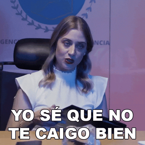 a woman is sitting at a desk and says yo se que no te caigo bien in spanish