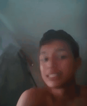 a young man without a shirt is taking a selfie with a camera .