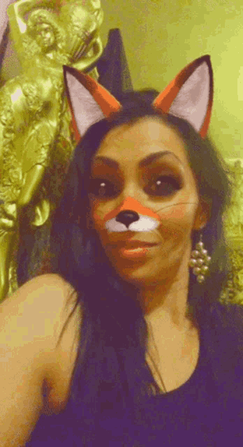 a woman with fox ears painted on her face takes a selfie