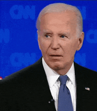 a man in a suit and tie with cnn in the background