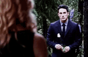 a man in a suit holding a white rose
