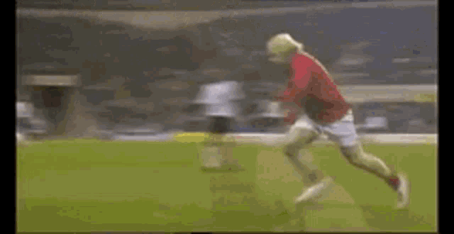 a soccer player in a red shirt is running on the field