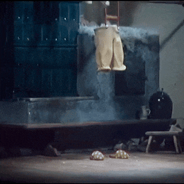 a pair of pants are hanging from a ladder in a dark room