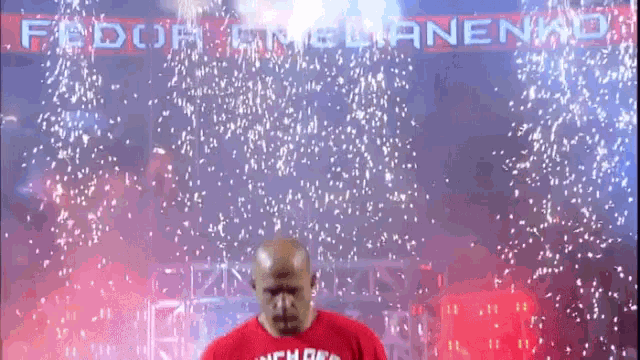 a man in a red shirt is standing in front of a banner that says fedor