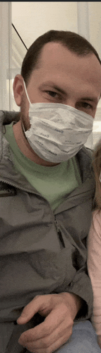 a man wearing a face mask is holding a baby