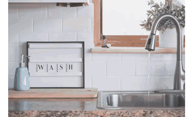 a kitchen sink with a sign above it that says " wash "