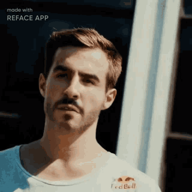 a man with a beard is wearing a white shirt that says red bull