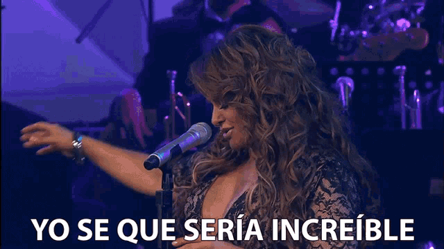 a woman singing into a microphone with yo se que seria increible below her