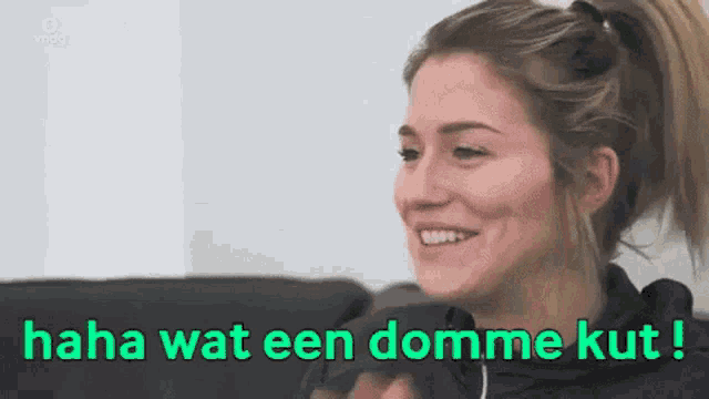 a woman is sitting on a couch and smiling with the words haha wat een domme kut
