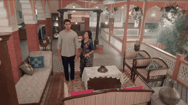 a man and woman are standing in a living room holding hands