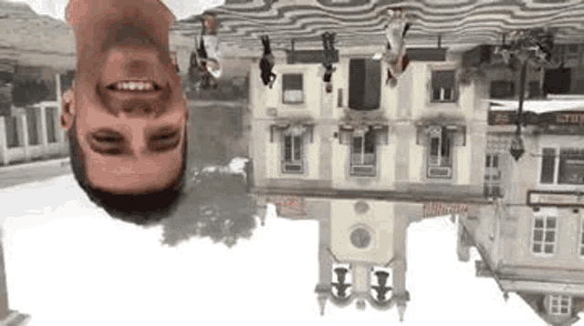 a man is upside down in front of a building and smiling .