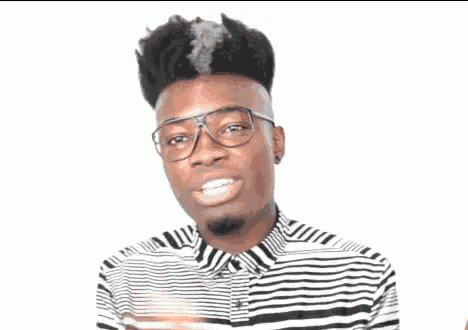 a young man with glasses and a striped shirt is making a funny face .