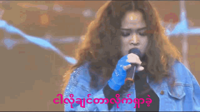 a woman with long hair is singing into a microphone