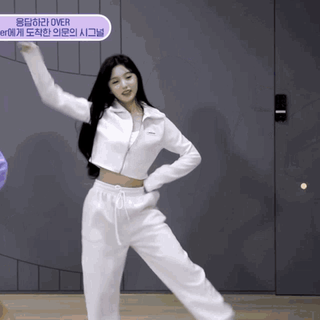 a woman in a white crop top and sweatpants is dancing in front of a purple sign that says over