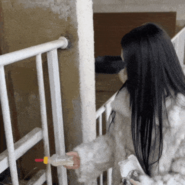 a woman in a fur coat is feeding a baby bottle