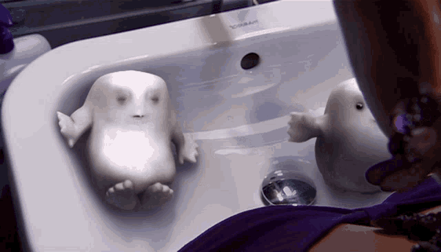 a person is washing their hands in a sink with a bottle of toothpaste