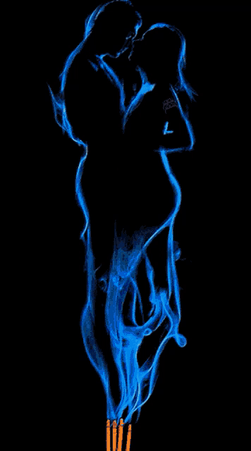 a silhouette of a man and a woman is made out of blue smoke