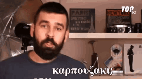 a man with a beard is standing in front of a shelf with a sign that says paris metro on it
