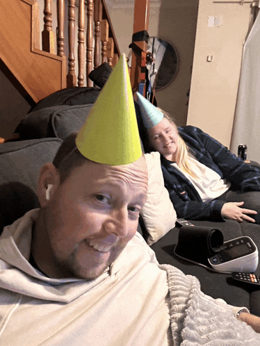a man wearing a party hat sits on a couch