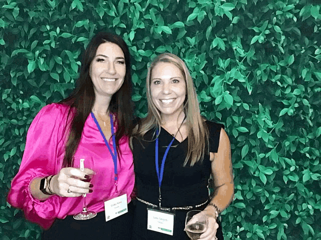 two women posing for a picture with one wearing a lanyard that says ' chris ' on it