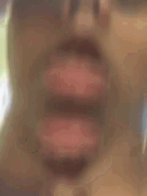 a close up of a person 's face with a blurry background .