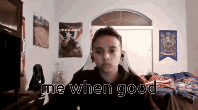 a boy in a room with a texans poster on the wall