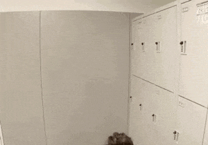 two women are standing next to each other in a locker room and smiling .