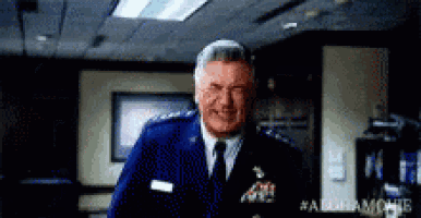 a man in a blue uniform and tie is standing in a room .