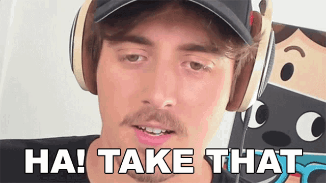 a man wearing headphones and a hat says " ha take that "