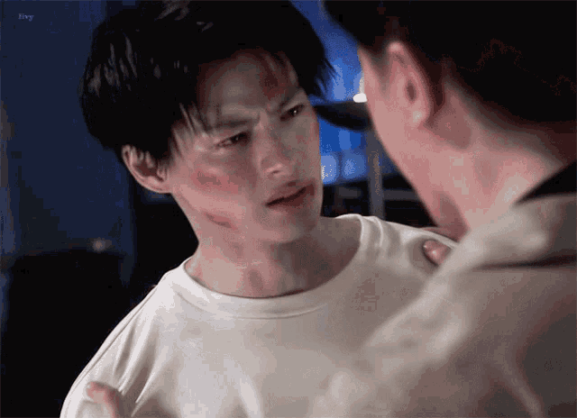 a man with a bloody face is talking to another man