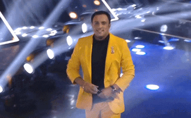 a man in a yellow suit is standing in front of a crowd